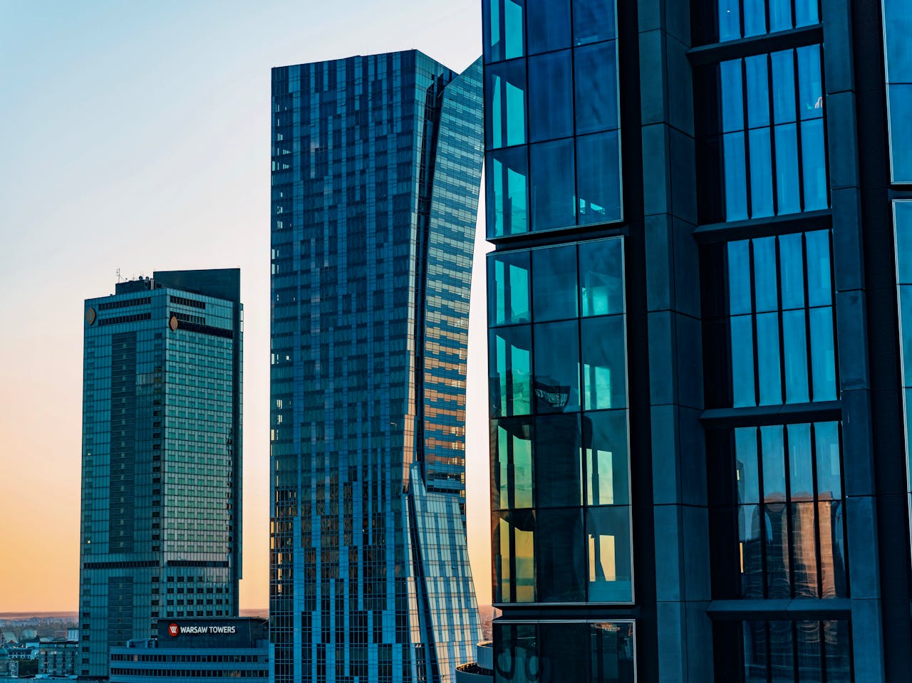 Contemporary skyscrapers with glass facades in downtown at twilight, showcasing modern architecture.